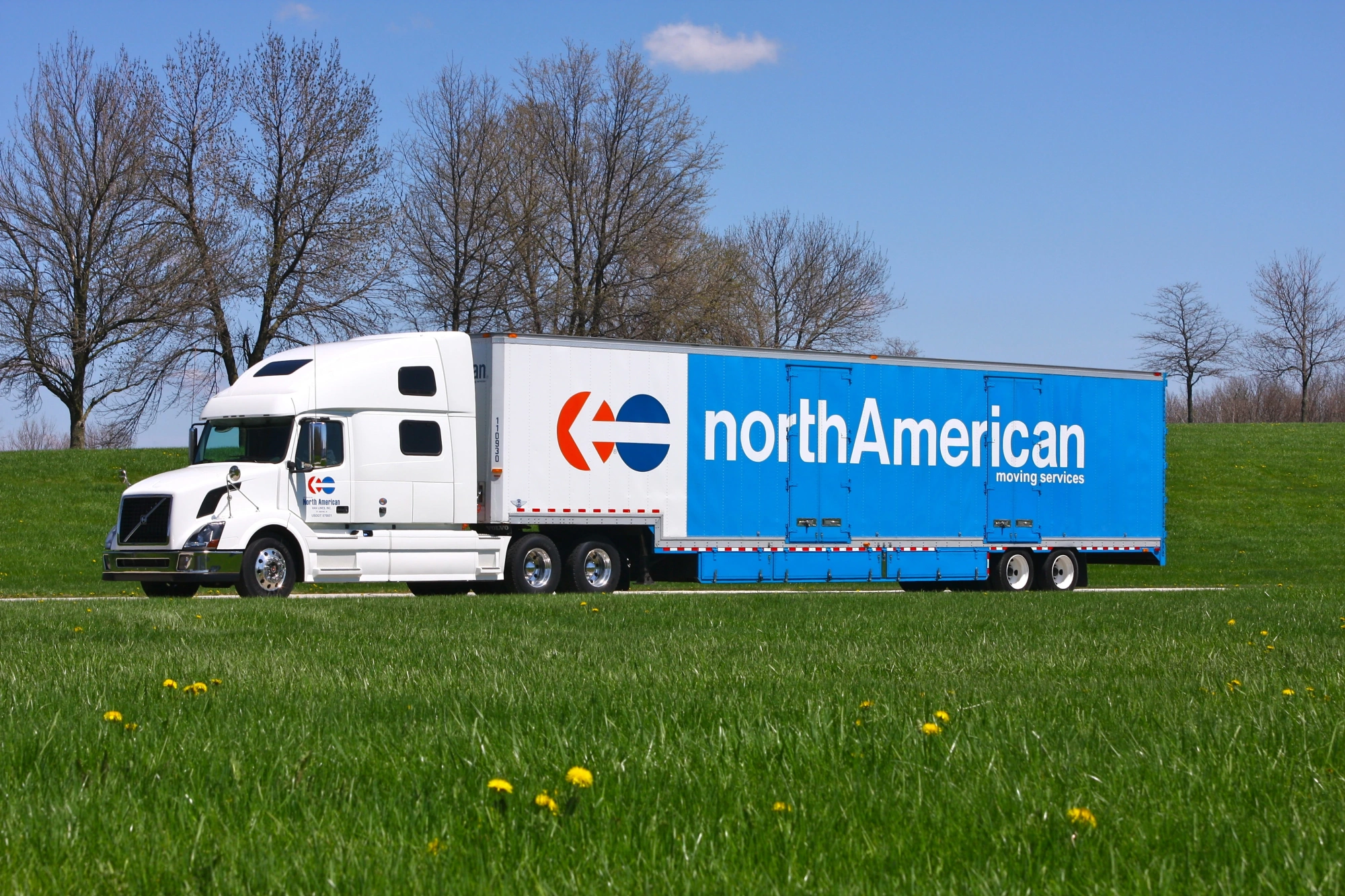 North American Van Lines truck on road through grassy field